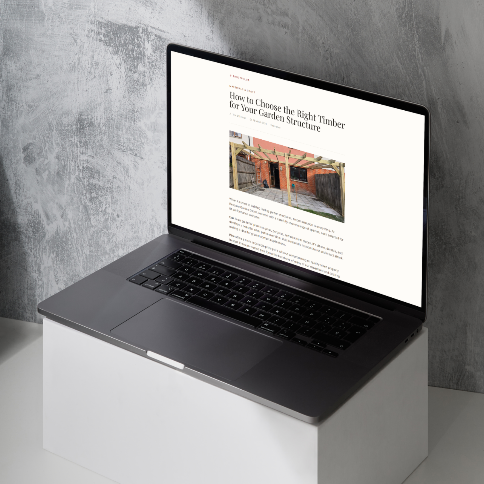 Bespoke Garden Decor — a journal article on choosing timber, open on a laptop above a full-width photograph